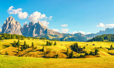 The rolling green pastures of Alpe di Siusi are framed by Italy's iconic Dolomite peaks.