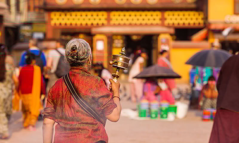 Nepalese woman with prayer wheel.