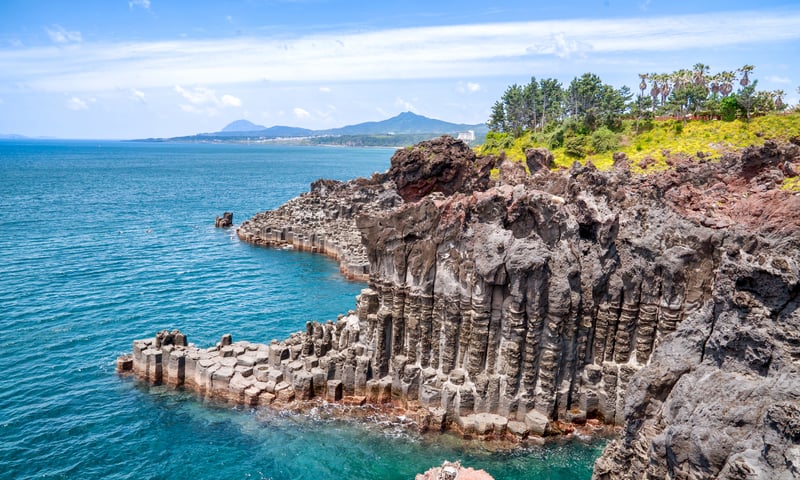 Take in the stunning rocky volcanic coastline of Jeju Island, South Korea.