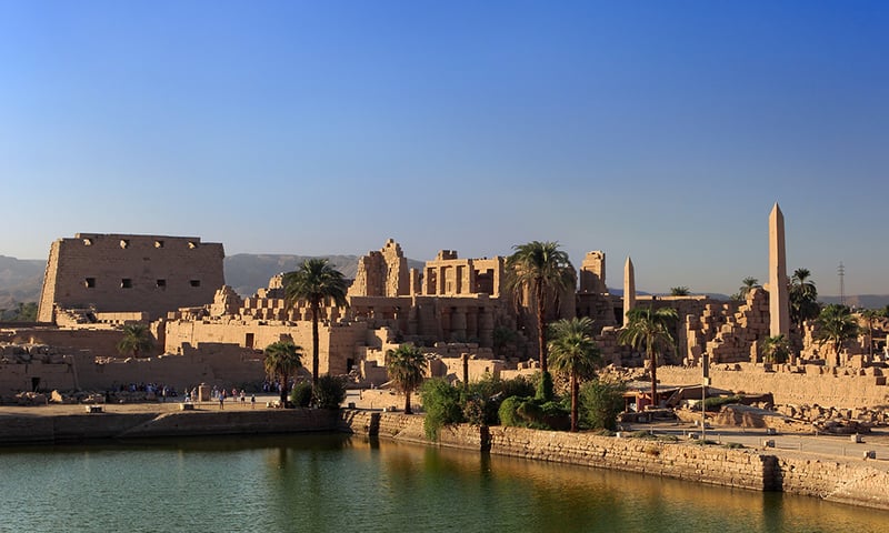 The vast and impressive Karnak Temple seen from the Sacred Lake, Luxor, Egypt.