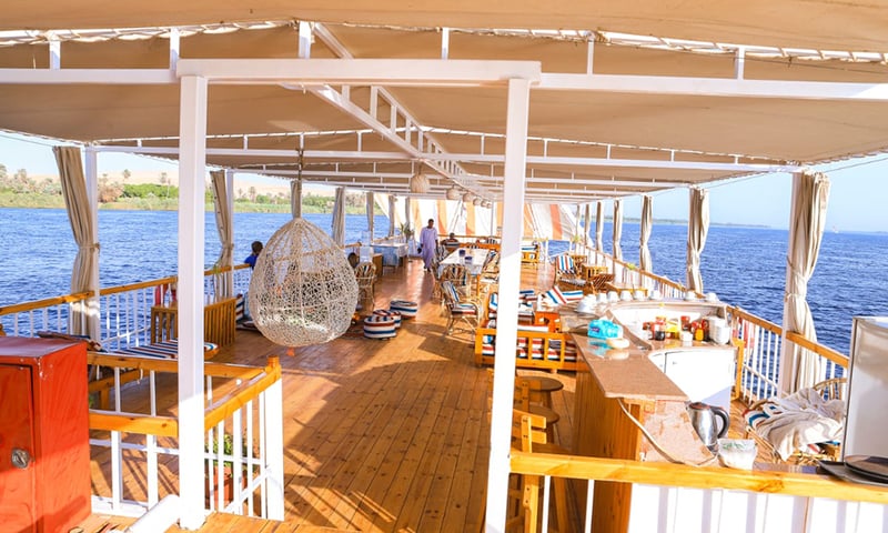 View everyday life on the Nile's riverbanks from the deck of the Dahabiya Sailboat.