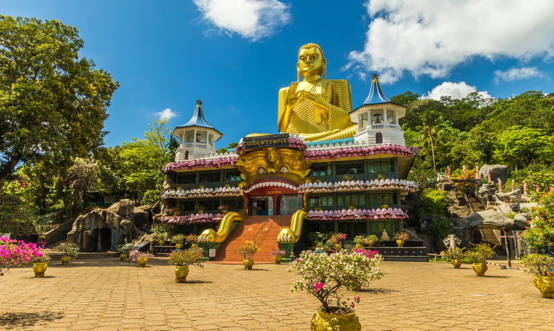 Marvel at the shining gold Buddha statue at Dambulla Rock Cave Temple.