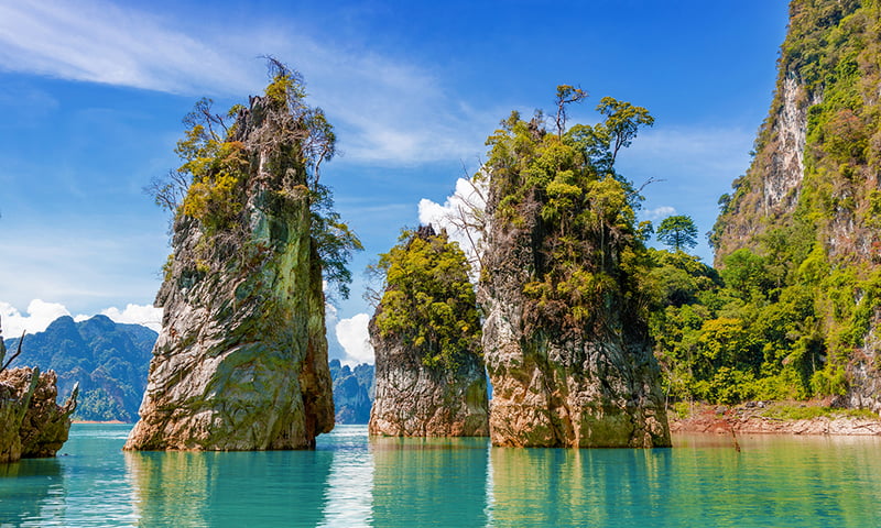 Cruise beneath the towering limestone karsts of Cheow Lan Lake.