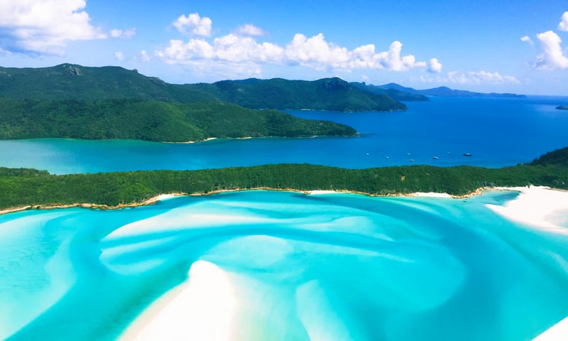 Take in the swirling blues and white hues of the Whitsunday Islands.