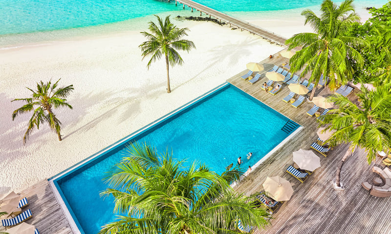 Relax by the pool at the Robinson Noonu Resort.
