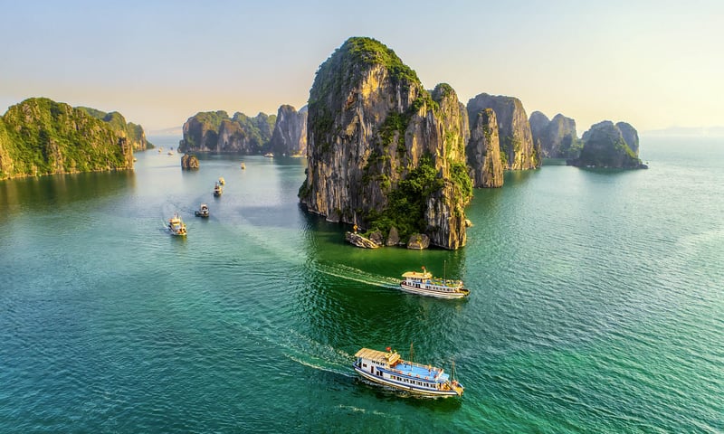 See Ha Long Bay,  famous for its emerald waters scattered with  limestone towers in Vietnam.