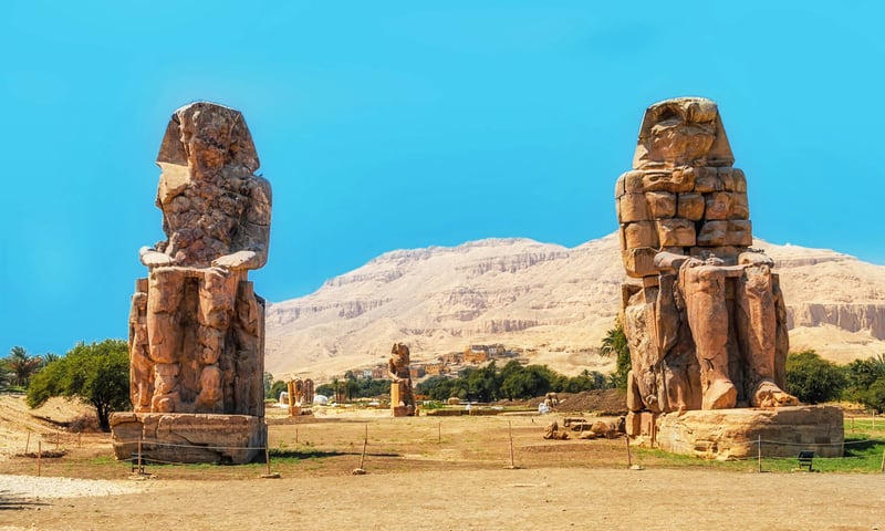 The Colossi of Memnon are two massive stone statues from the time of Pharaoh Amenhotep III.