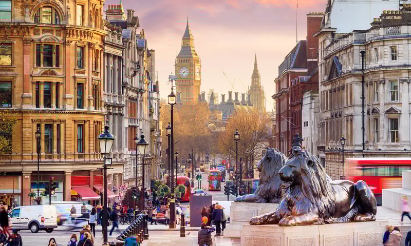Walk through bustling Trafalgar Square in London, England.