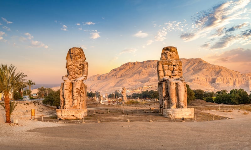 See the Colossi of Memnon, massive statues honouring Pharaoh Amenhotep III.