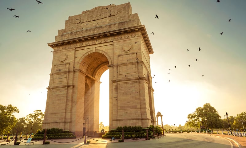 See India Gate, a towering stone arch that stands as a solemn war memorial.