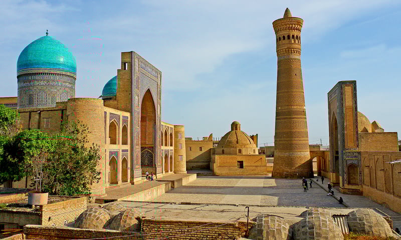 Stand in awe beneath the Poi Kalon Minaret in Bukhara, Uzbekistan.
