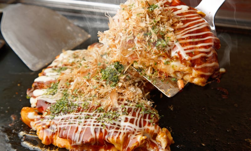 Treat yourself to traditional Okonomiyaki in Hiroshima, Japan (charges apply).