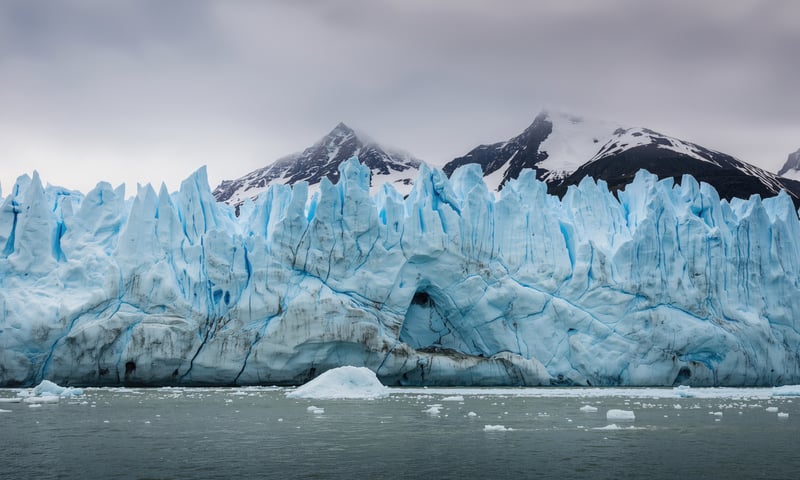 Calving ice crumbles into the water, creating new icebergs at Eqi Glacier, Greenland.
