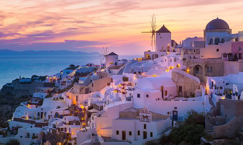 See Oia's magnificent sunsets and iconic windmills, Santorini, Greece.