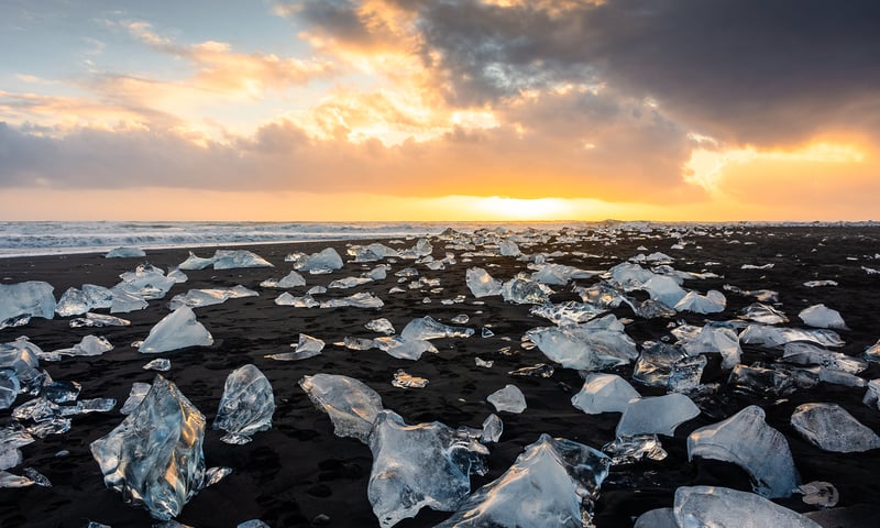 Step among shimmering ice chunks on the black sand of Diamond Beach, Iceland.
