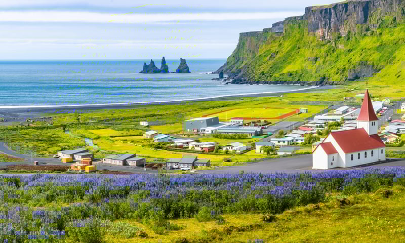 Emerald hills meet black volcanic sands at Vik in southern Iceland.
