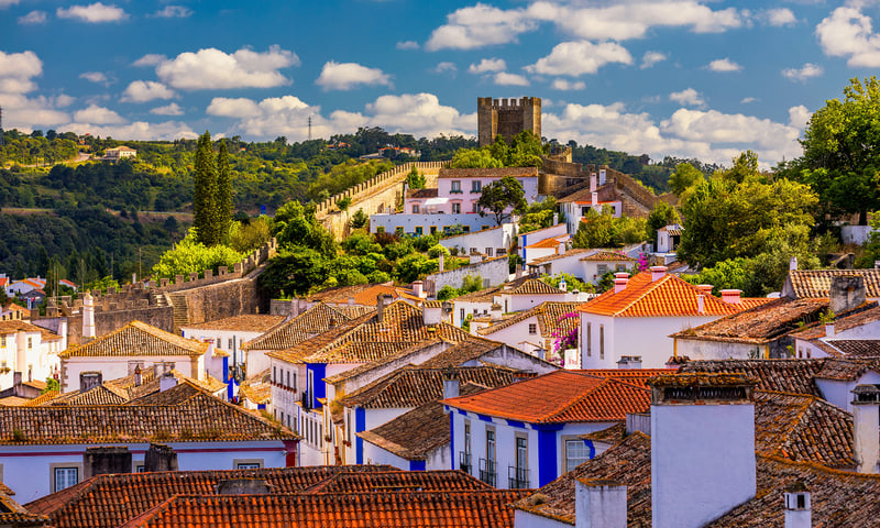 Explore picturesque streets and medieval fortress in the walled town of Obidos, Portugal.