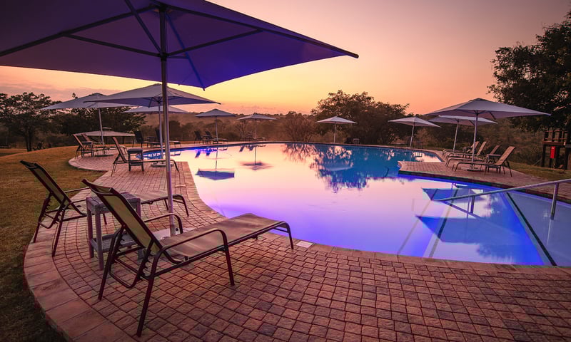 Treat yourself to a sundowner by the pool after a full-day's safari adventure.