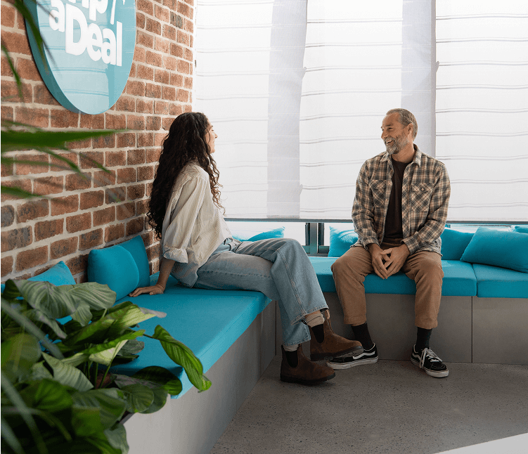2 TripADeal staff members conversing in a breakout area